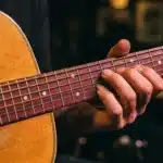 Main de musicien sur le manche d'une guitare acoustique