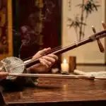 Homme jouant instrument à cordes asiatique traditionnel en bois
